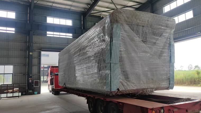 Upakovana SPACEHOME kapsula na poluprikolici u fabričkoj hali, bočni pogled