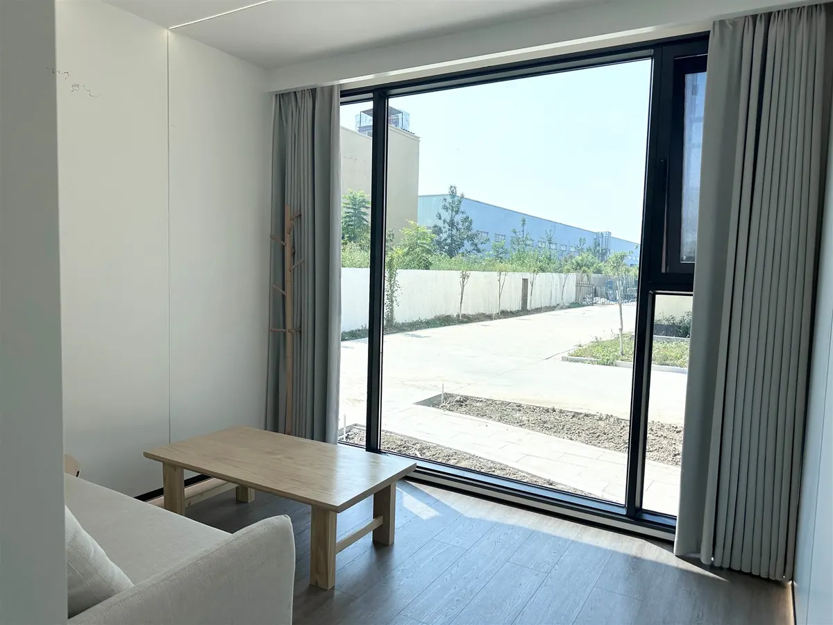 Wohnbereich mit Sofa, Couchtisch und großer Glasfront