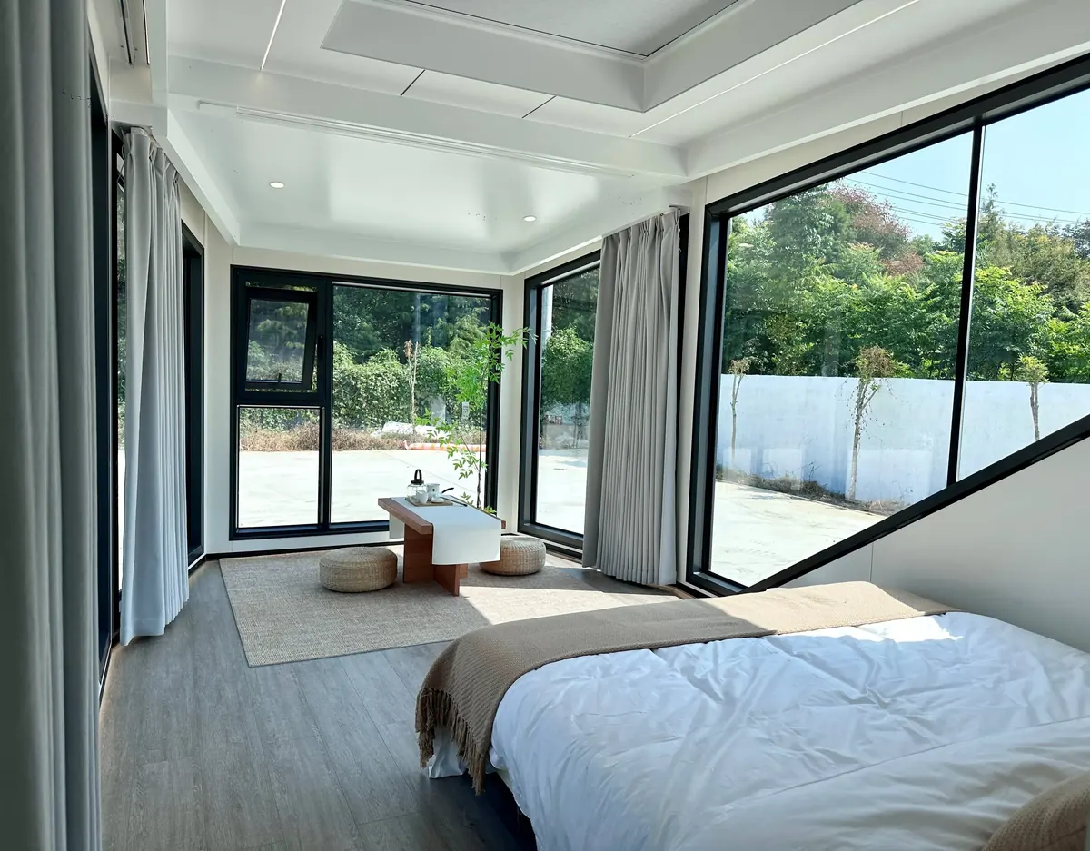 Schlafbereich mit Doppelbett unter schrägen Panoramafenstern